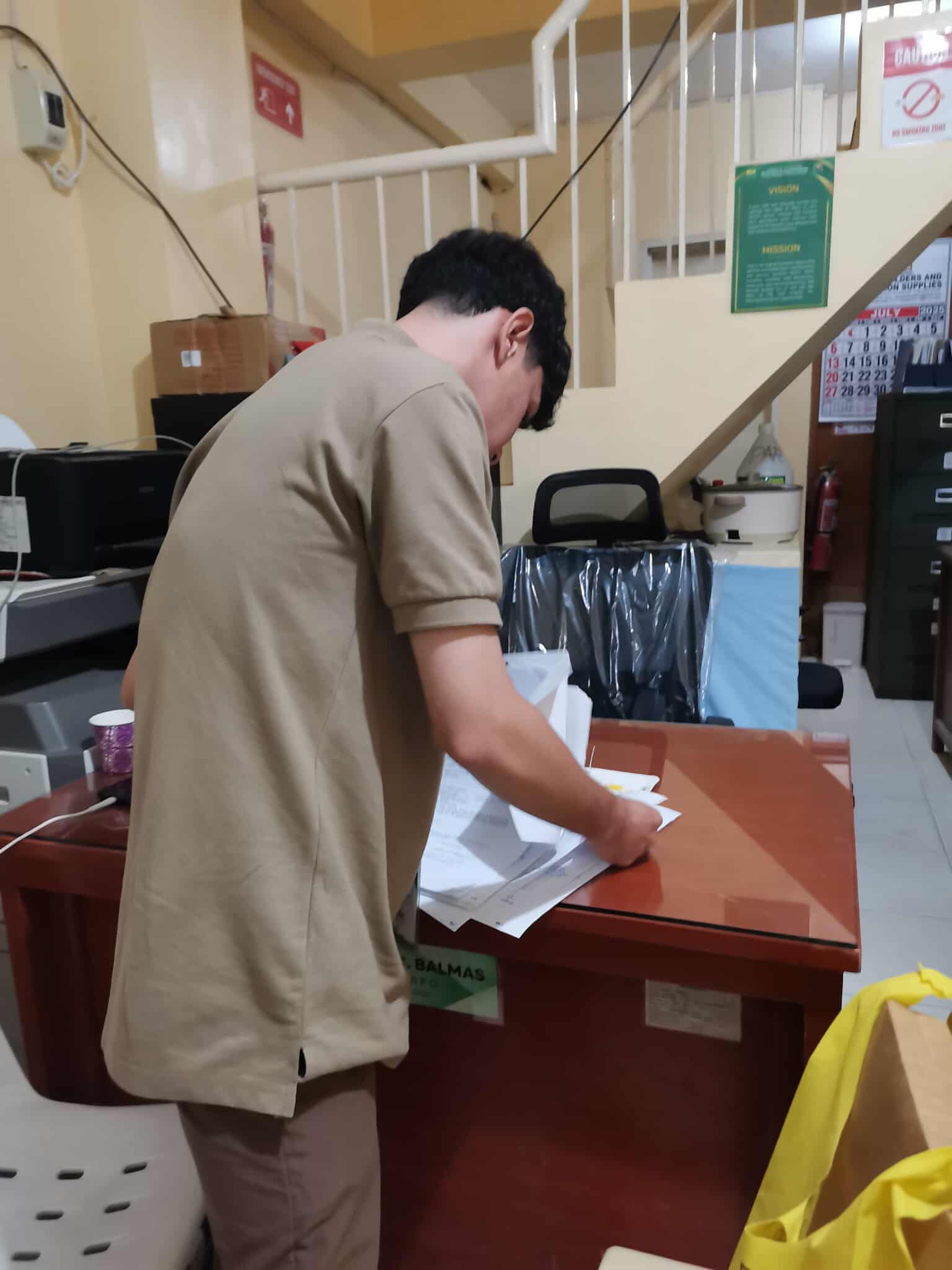 Zaldy organizing office documents during his OJT at DAR Masbate